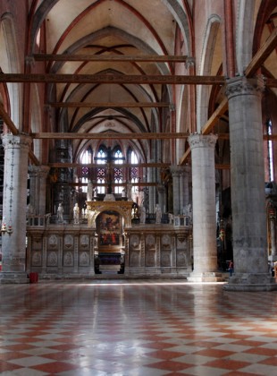 View of the nave of Santa Maria Gloriosa dei Frari, looking through the gate of the Schola Cantorum toward Titian's sumptuous Assumption of the Virgin over the high altar. Note that no tiles in the floor have been left missing for the sake of historical meaning.
[Image source]